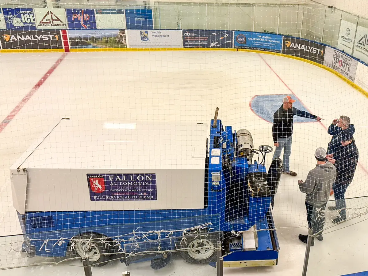 SDC staff driving a Zamboni across and ice rink.